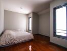 Bedroom with windows and wooden floor