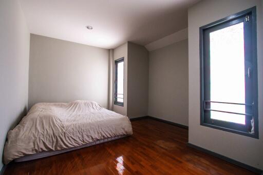 Bedroom with windows and wooden floor