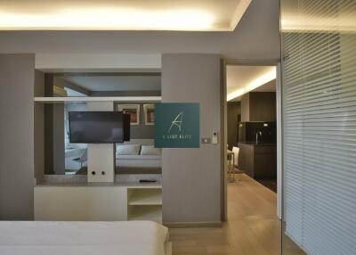 Modern bedroom with a view into the living area and kitchen