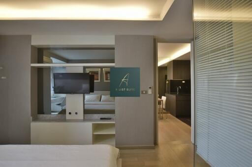 Modern bedroom with a view into the living area and kitchen