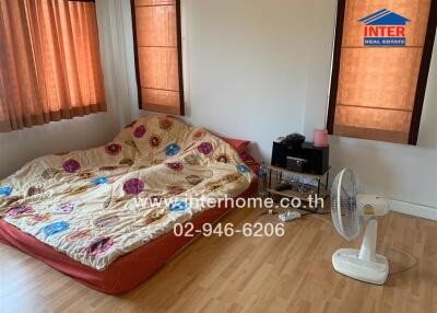 Simple bedroom with mattress on the floor and wooden flooring