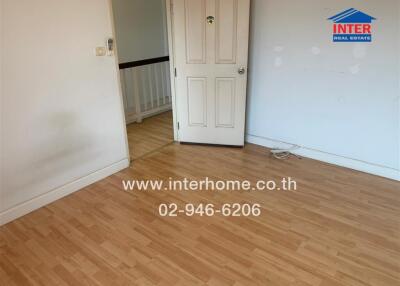 Empty room with wooden floor and a door