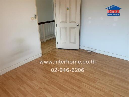 Empty room with wooden floor and a door