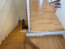 Indoor wooden stairs leading up to a wooden landing area.