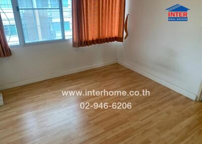 Unfurnished room with wooden flooring and large window with curtains