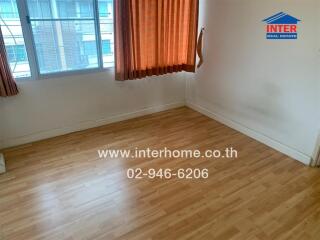 Unfurnished room with wooden flooring and large window with curtains