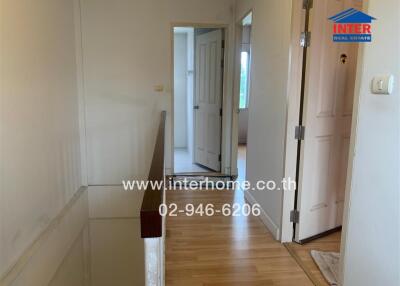 Indoor hallway with wooden floor and doors leading to different rooms