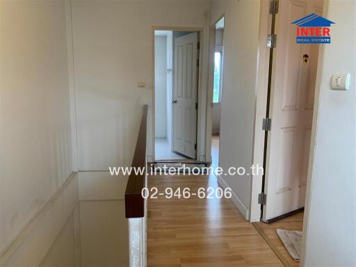 Indoor hallway with wooden floor and doors leading to different rooms