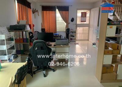 Office space in house with desk, chair, shelves, and staircase