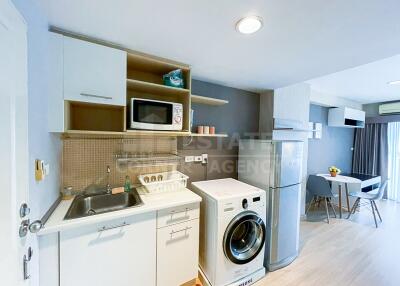 Modern kitchen area with washing machine and dining space