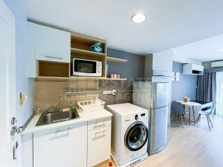 Modern kitchen area with washing machine and dining space