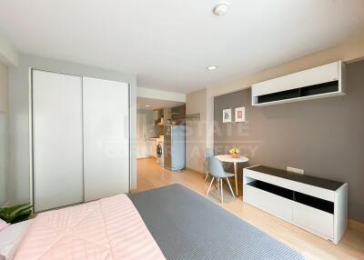 Modern studio apartment with bed, dining area, and kitchen