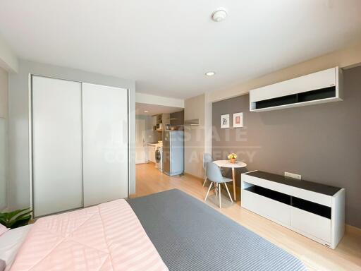 Modern studio apartment with bed, dining area, and kitchen