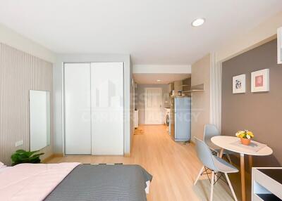 Cozy bedroom with modern decor, a dining area, and a partial view of the kitchen