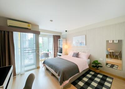 Modern bedroom with a bed, desk, and a window with a view