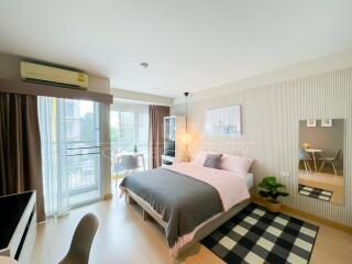 Modern bedroom with a bed, desk, and a window with a view