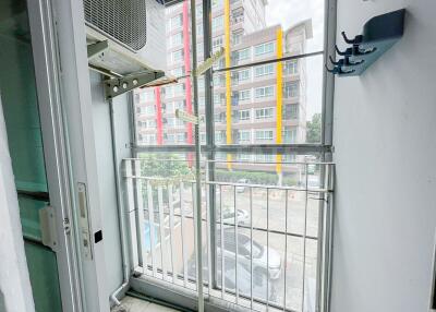 View of balcony with glass doors overlooking urban apartment buildings