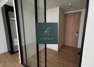 Modern apartment entryway with wood flooring and glass closet doors.