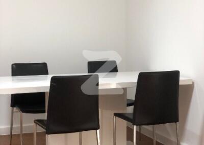 Modern dining area with white table and black chairs