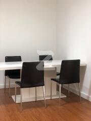 Modern dining area with white table and black chairs