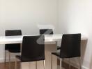 Modern dining area with white table and black chairs