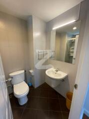 Modern bathroom with toilet, sink, and mirror