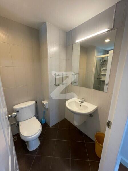 Modern bathroom with toilet, sink, and mirror