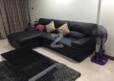 Living room with black L-shaped sofa and modern coffee table