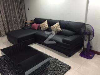 Living room with black L-shaped sofa and modern coffee table