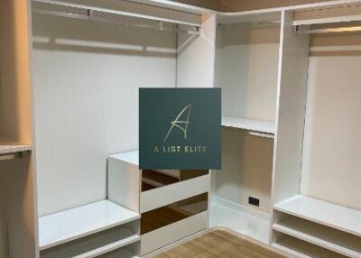 Walk-in closet with wooden flooring and built-in white shelves