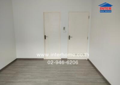 Empty room with wooden floor and two doors