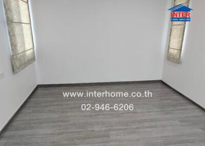 Unfurnished bedroom with wooden floor and windows