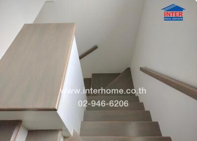 Staircase with wooden steps and white walls