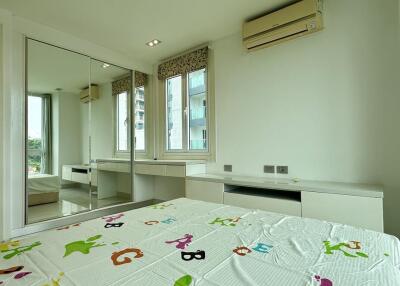 Bedroom with mirrored closet doors, large windows, and built-in desk