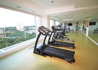 A modern gym with treadmills and large windows offering a scenic view.