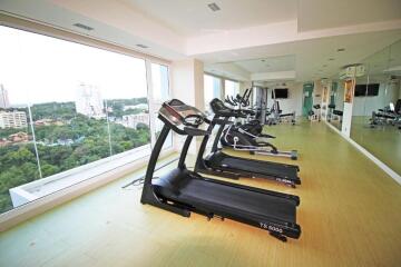 A modern gym with treadmills and large windows offering a scenic view.