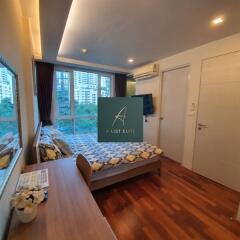 Modern bedroom with large window and wooden flooring