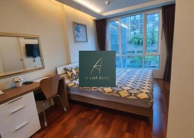 Modern bedroom with wooden flooring and large windows