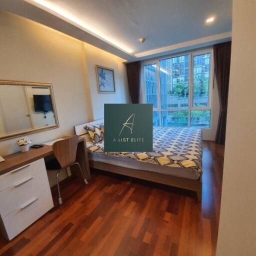 Modern bedroom with wooden flooring and large windows