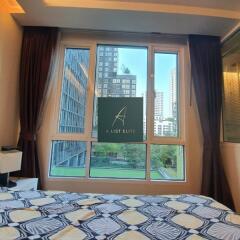 Bedroom with large window and cityscape view