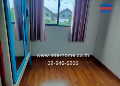 Modern bedroom with hardwood floor and large window