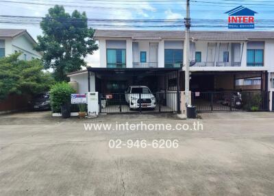 Front view of a residential townhouse with parking area