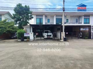 Front view of a residential townhouse with parking area