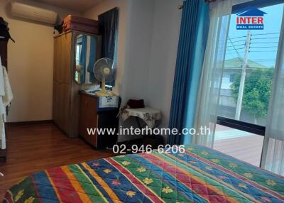 Bedroom with colorful bedding, wardrobe, and a window