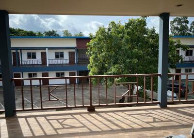 Second floor balcony with view of adjacent building and trees