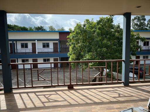 Second floor balcony with view of adjacent building and trees