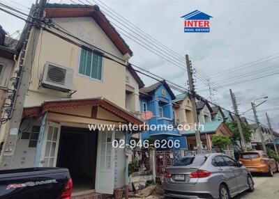 Exterior view of a row of houses with cars parked outside