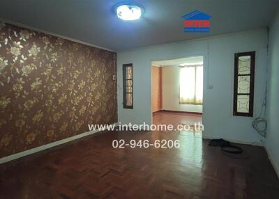 Living room with patterned wallpaper and wooden flooring