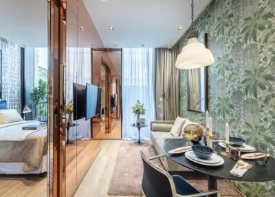 living area with dining table, sofa, and view into the bedroom