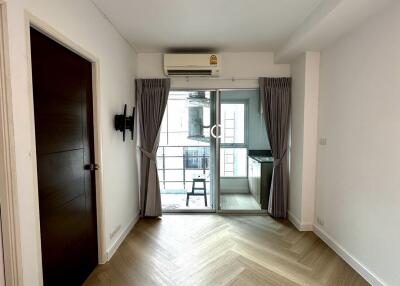 Bright main living area with wood flooring and access to a balcony